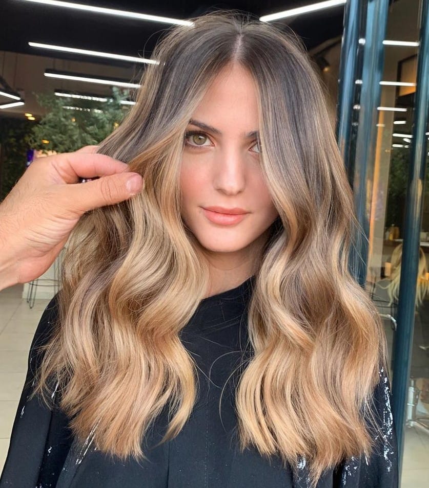 Stylist finishing a glossy balayage in the Maison Belle salon