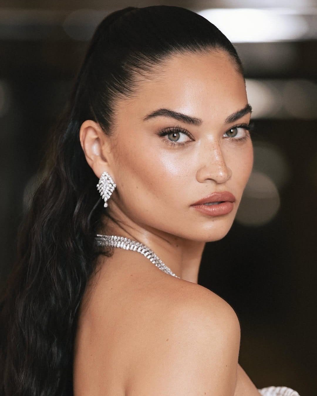 A client of Maison Belle, serene in diamond jewelry, looking back over her shoulder